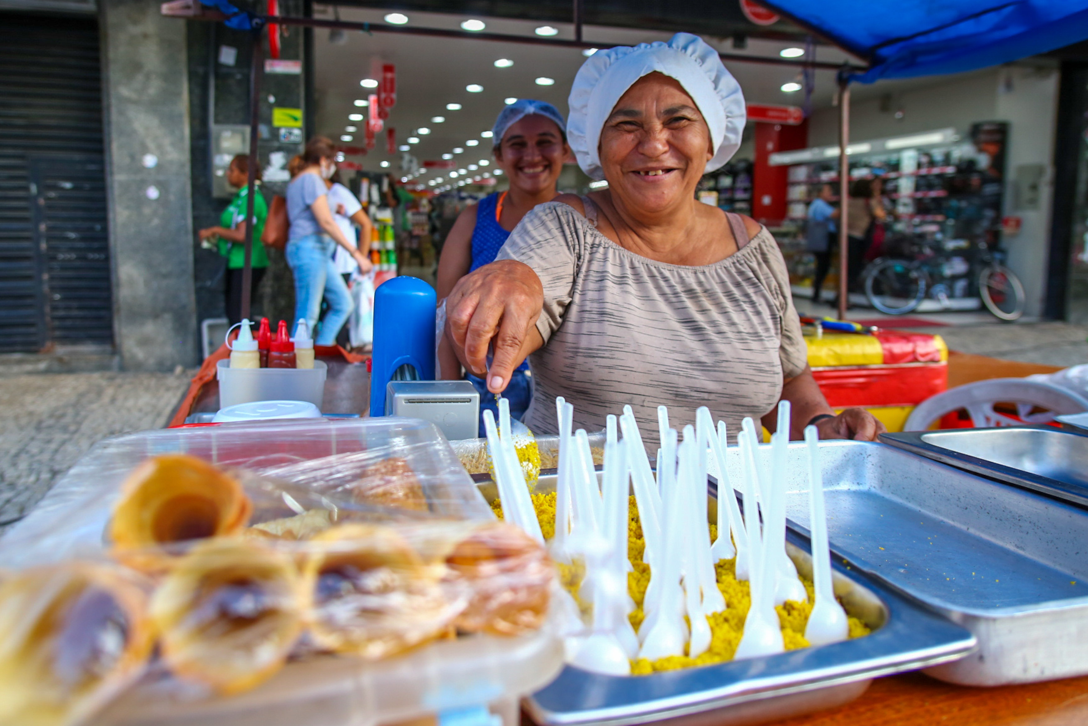 Conceição Veras posa para a foto em sua barraca de lanches