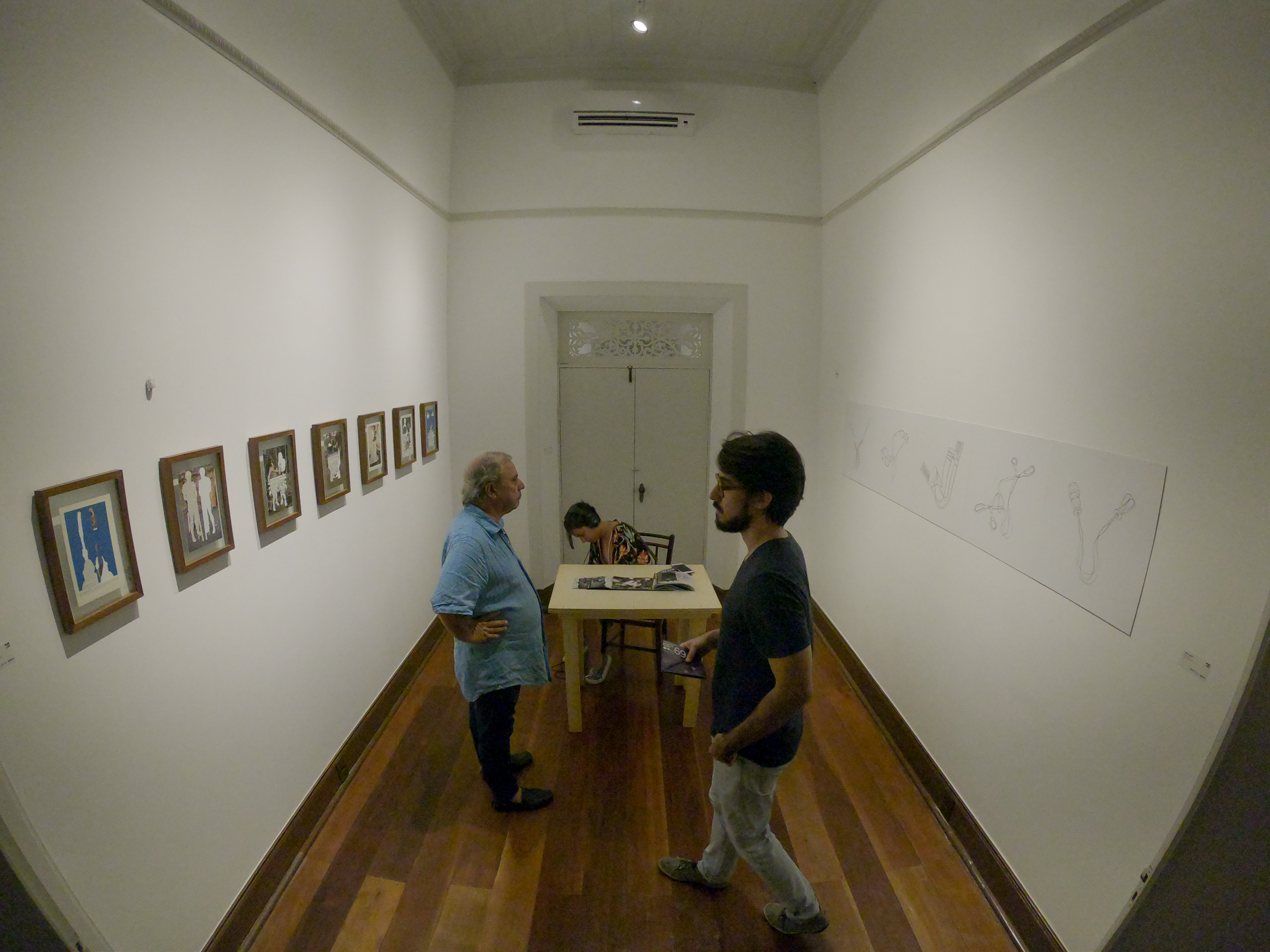 Visitantes do 69º Salão de Abril observam quadros expostos na Casa do Barão de Camocim