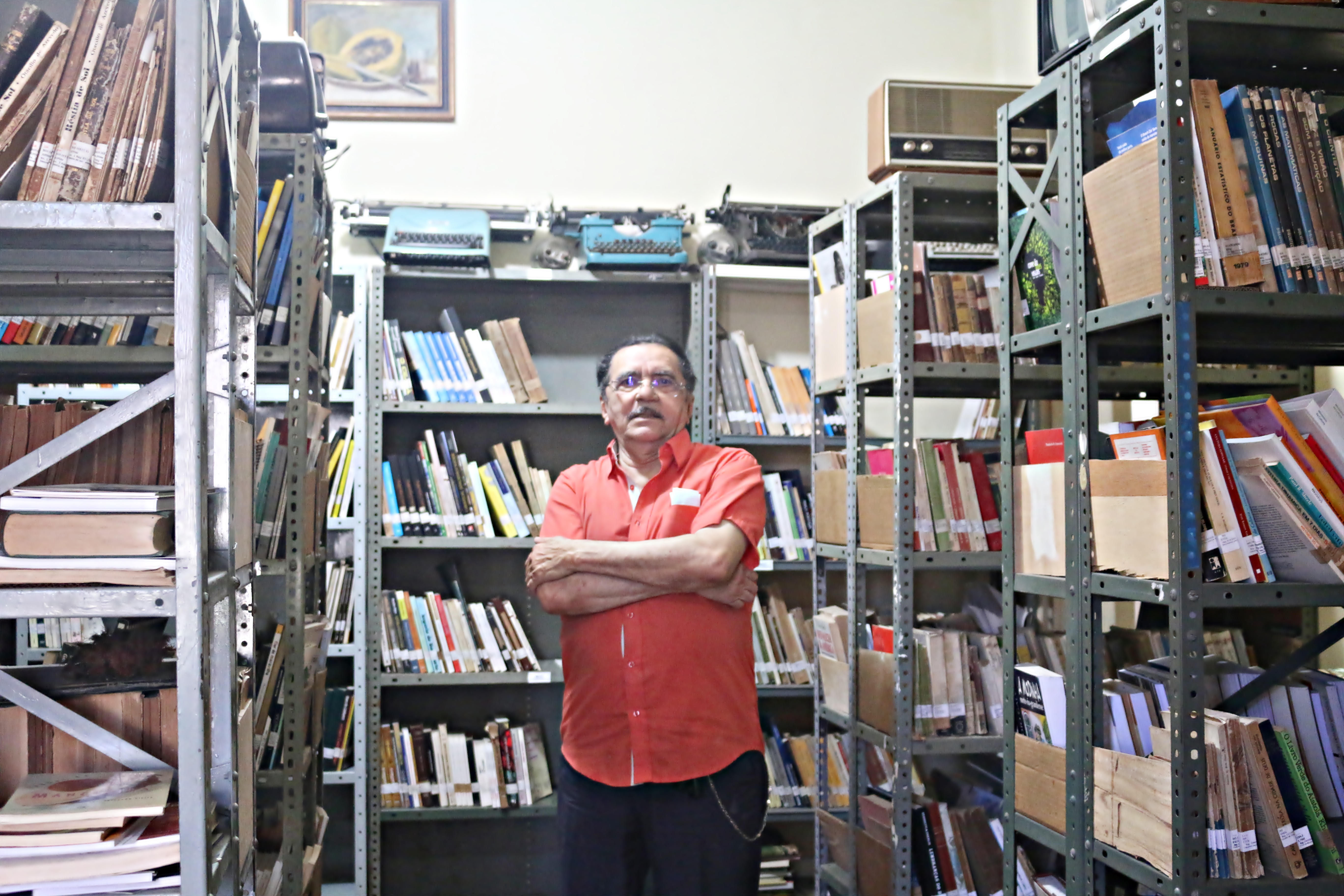 O memorialista Nirez em meio a vários livros e documentos empilhados nas prateleiras de seu arquivo