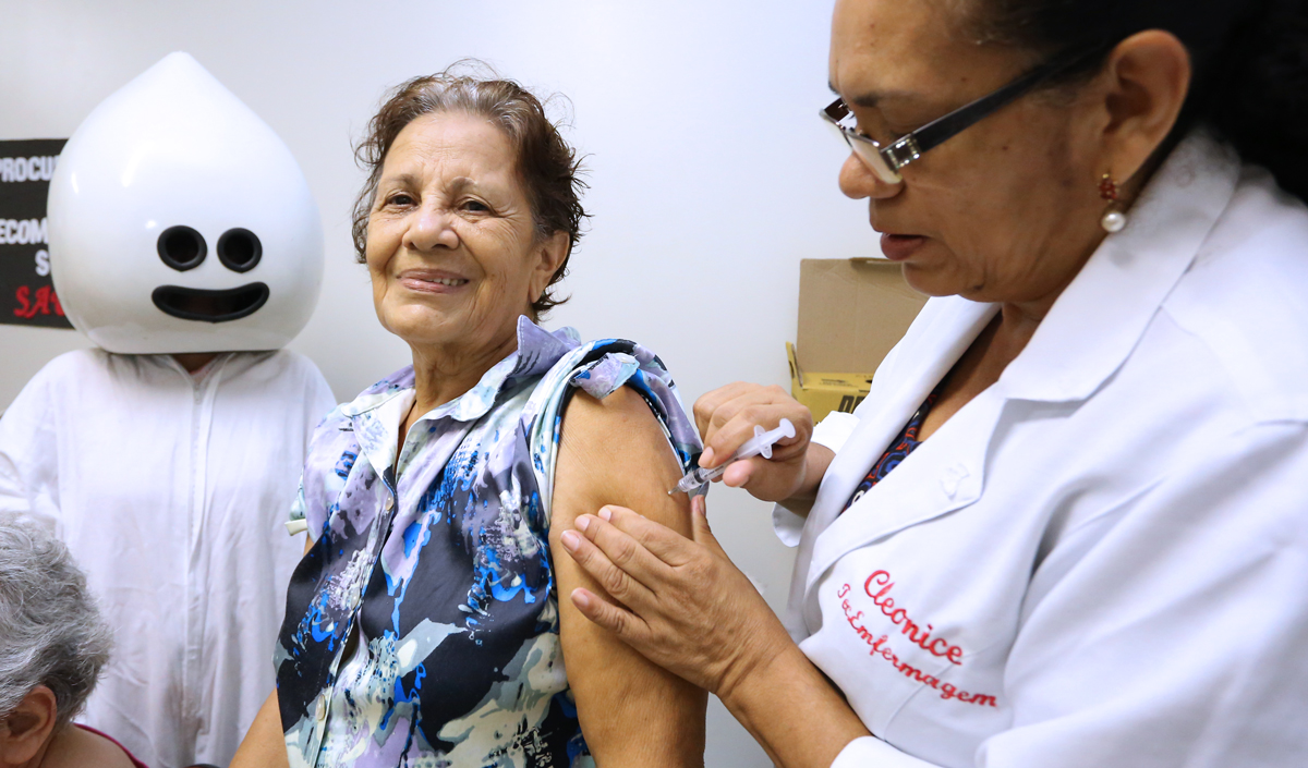 Vacinação de idosa em posto de saúde da capital