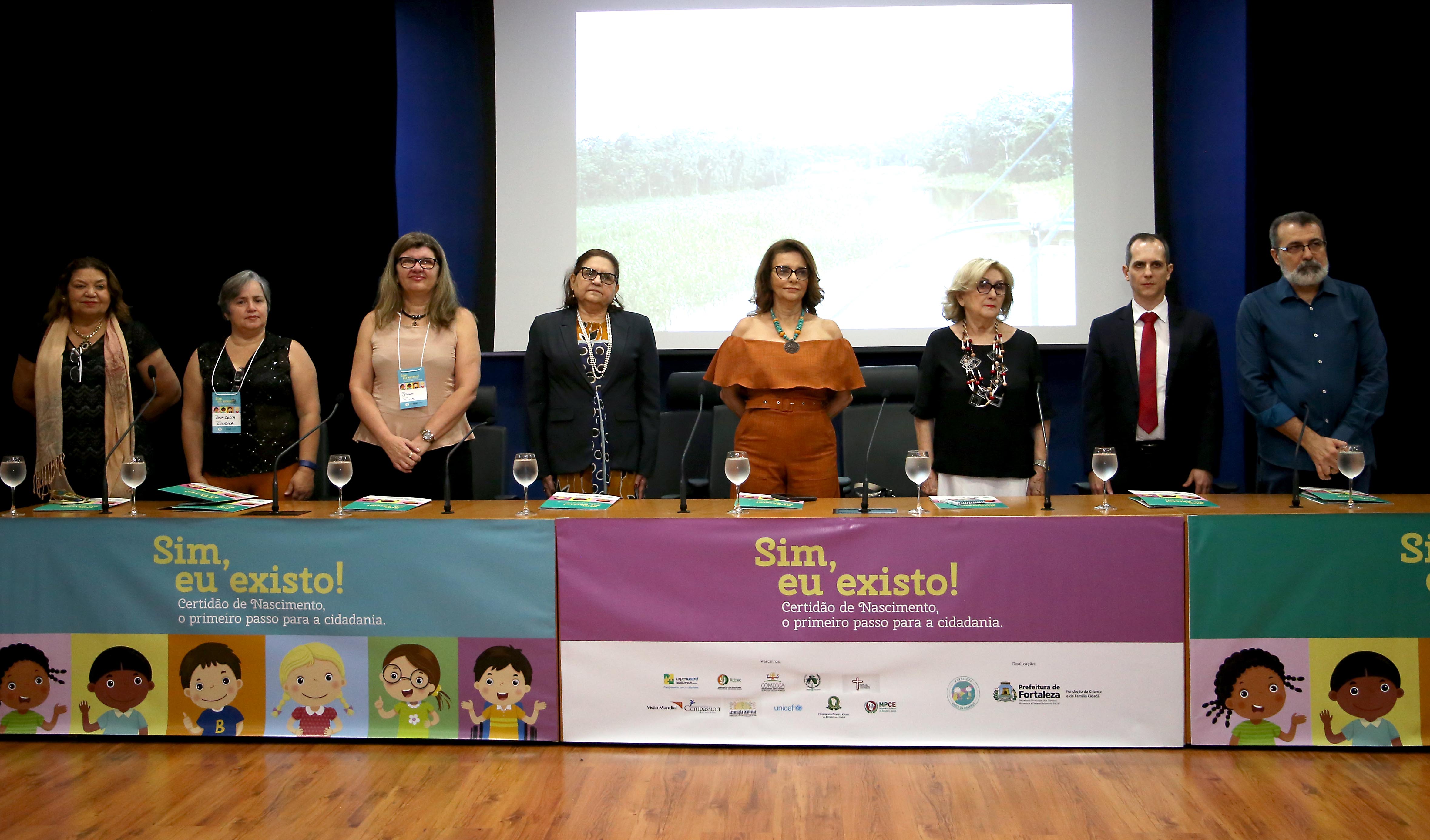 pessoas em pé atrás de mesa em cima de palco