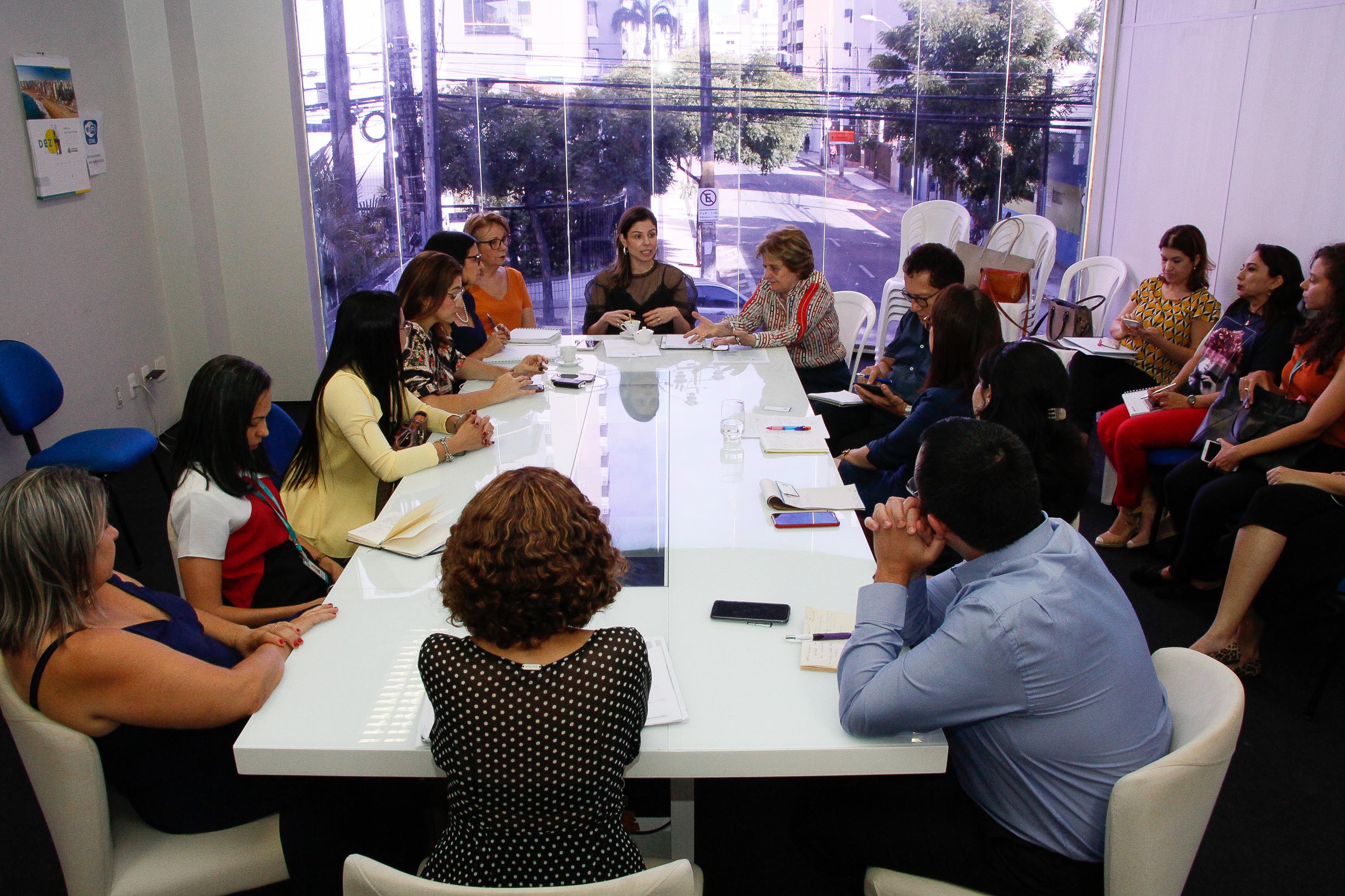 primeira-dama e pessoas sentadas conversando ao redor de mesa