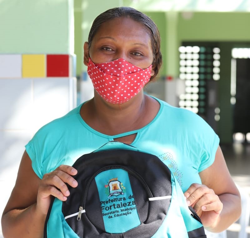 América Alves, mãe de aluno da Rede, segurando mochila entregue aos estudantes