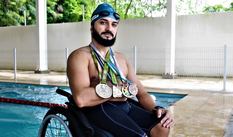 O atleta da Rede Cuca, Breno Soares, posa para a foto com várias medalhas penduradas no pescoço 