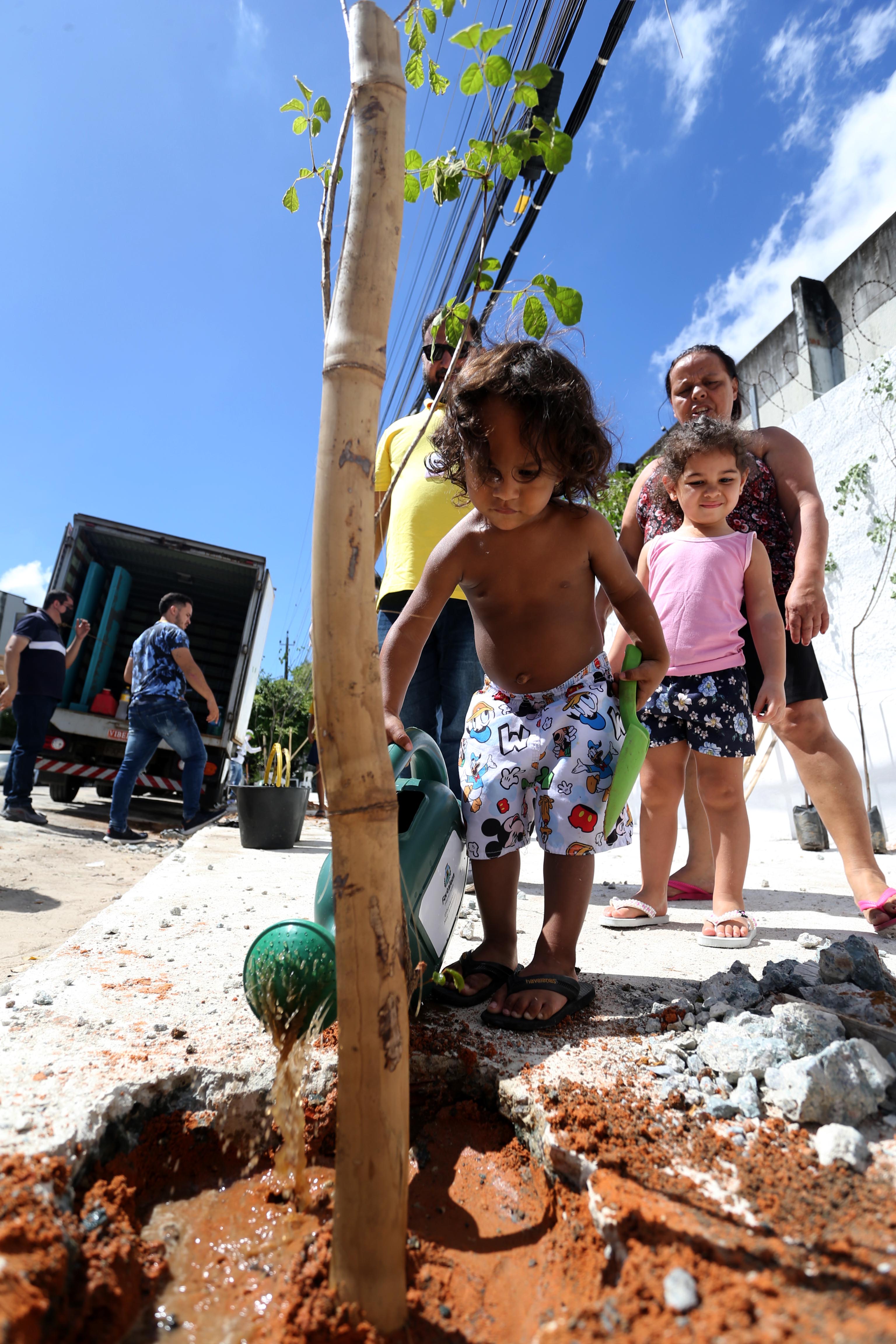 Crianças aprendem a plantar mudas em ação de revitalização de ponto irregular de lixo, no Jardim América