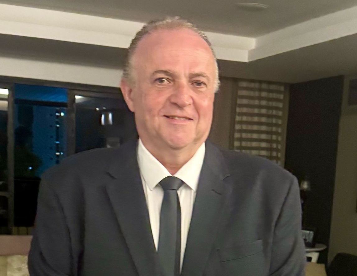 Washington Araruna posa para a foto, ele veste terno e gravata pretos e camisa branca