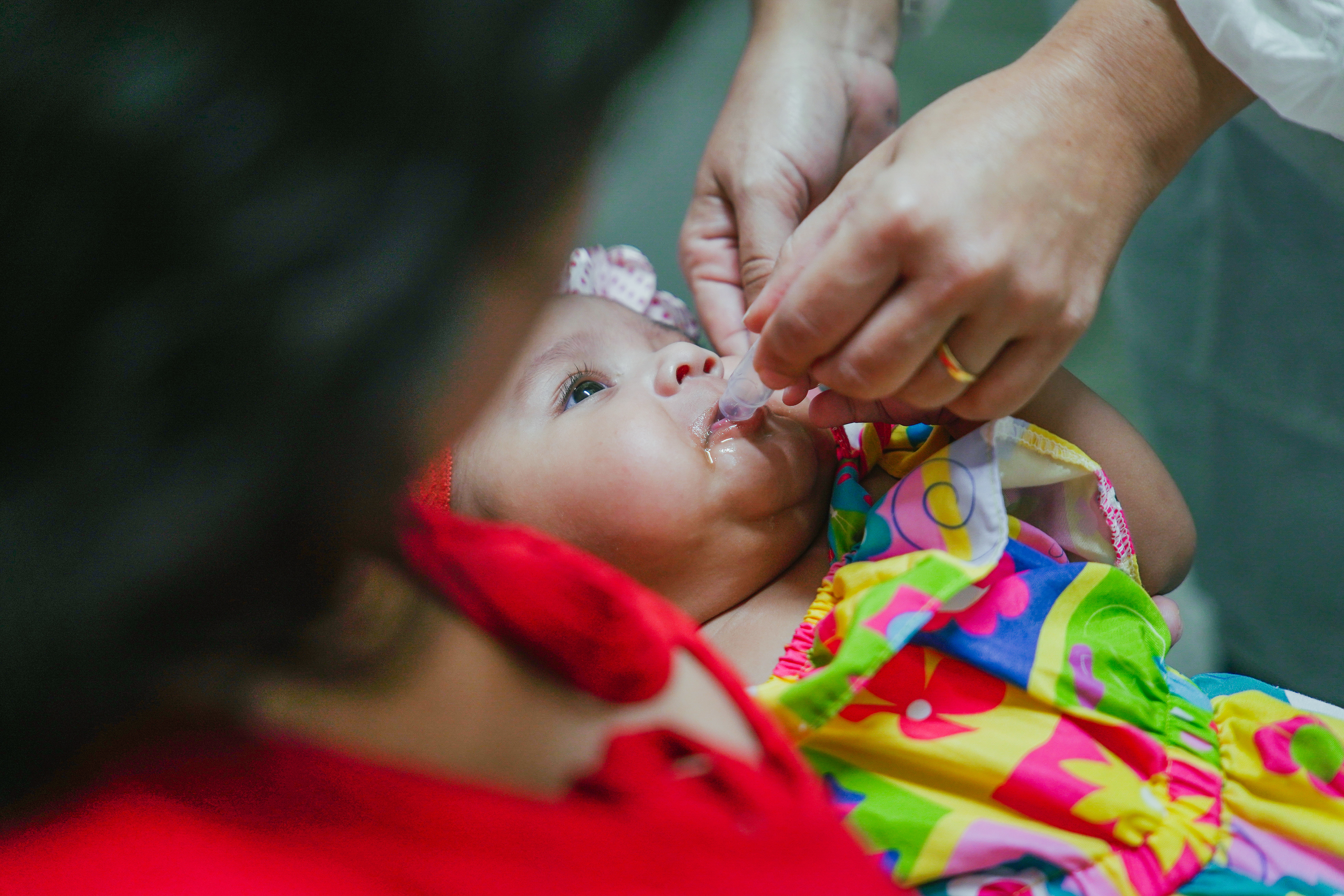 criança recebendo gotinha contra a poliomielite