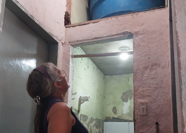 mulher observa a caixa d'agua